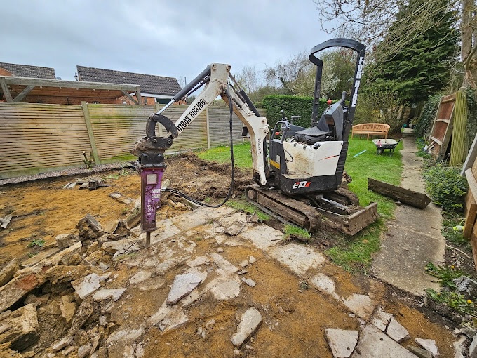 Micro digger carrying out excavation work in a residential garden